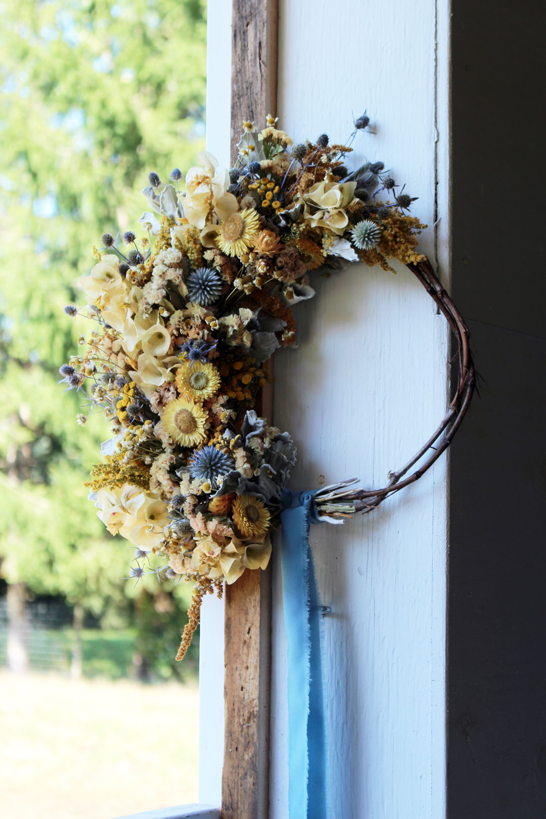 A dried wreath of yellow and blue summer flowers