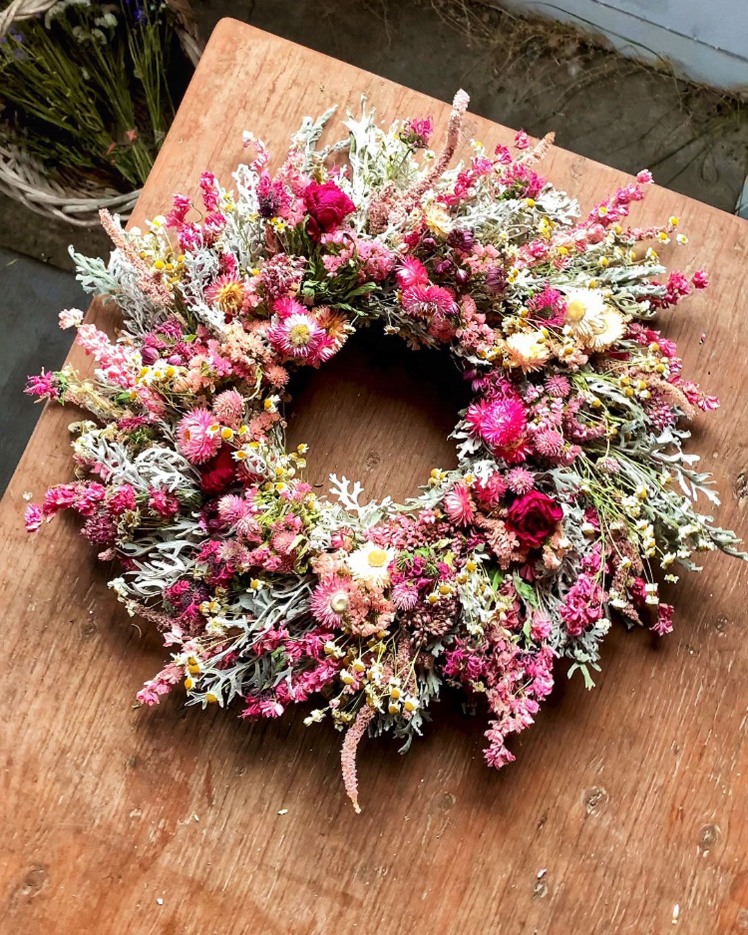 A wreath of pink dried flowers on my floral studio work table.